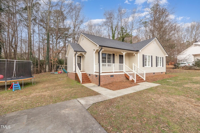 view of front facade with covered porch, a playground, a front lawn, and a trampoline