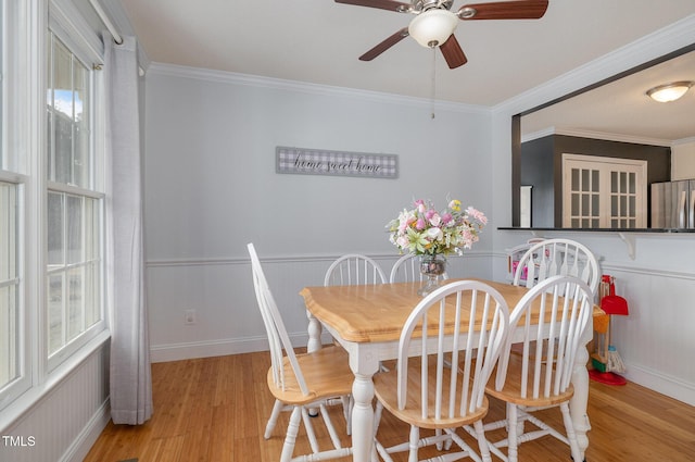 dining room featuring crown molding, plenty of natural light, and light wood-type flooring