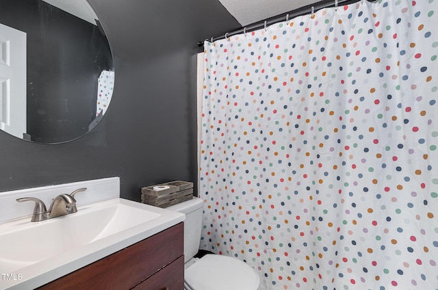 bathroom featuring vanity, toilet, and a textured ceiling