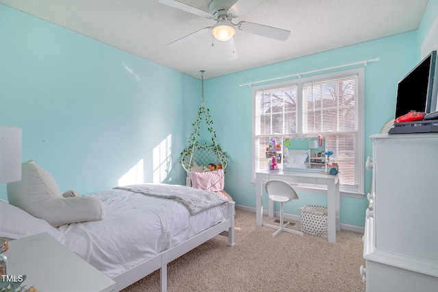 carpeted bedroom featuring ceiling fan and a textured ceiling