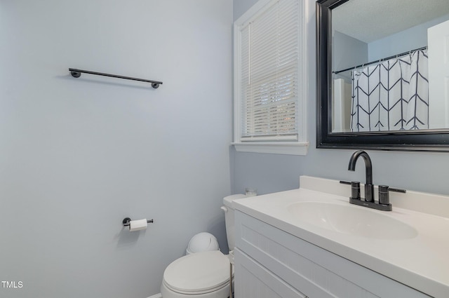 bathroom with vanity, a shower with shower curtain, and toilet