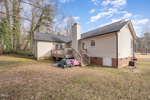 rear view of property featuring a wooden deck and a yard