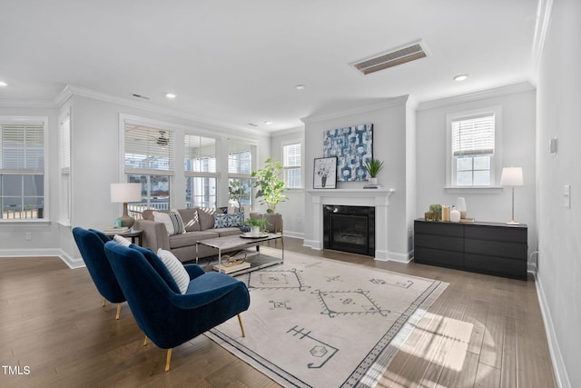 living room featuring crown molding, hardwood / wood-style floors, and a wealth of natural light