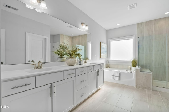 bathroom with tile patterned floors, vanity, and shower with separate bathtub