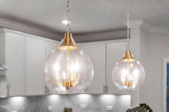 details featuring crown molding and white cabinets