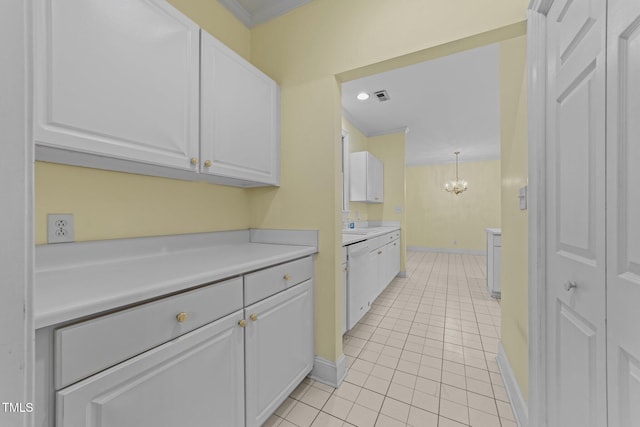 kitchen featuring an inviting chandelier, light tile patterned floors, white dishwasher, pendant lighting, and white cabinets