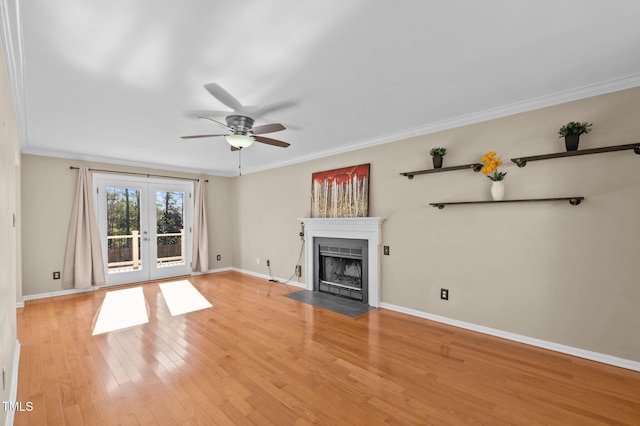 unfurnished living room with ornamental molding, ceiling fan, light wood-type flooring, and french doors