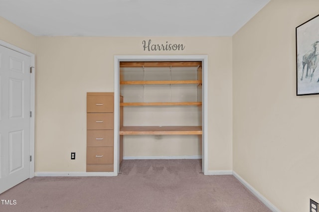 unfurnished bedroom featuring a closet and light carpet