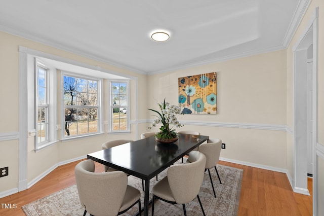 dining area with wood-type flooring and ornamental molding