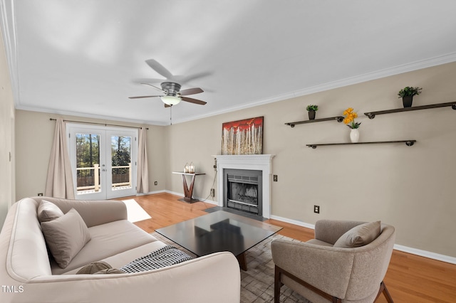 living room with french doors, ornamental molding, ceiling fan, and light hardwood / wood-style flooring