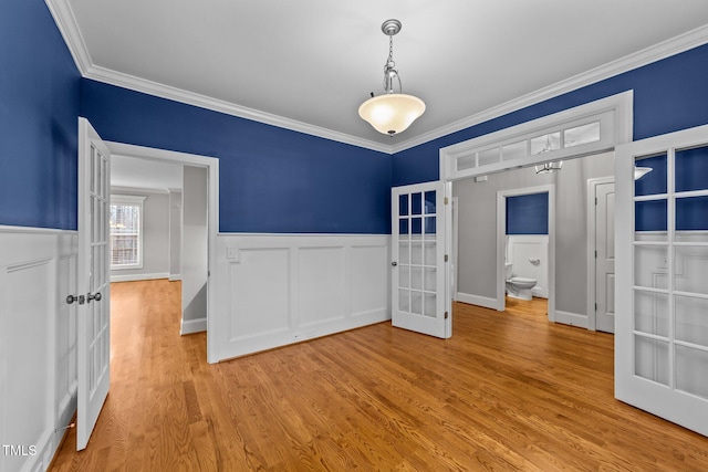 spare room with crown molding, light hardwood / wood-style floors, and french doors