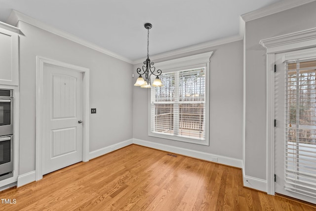 unfurnished dining area with a healthy amount of sunlight, ornamental molding, and light hardwood / wood-style floors