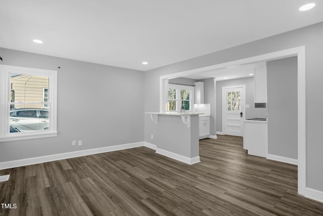 unfurnished living room with dark wood-type flooring