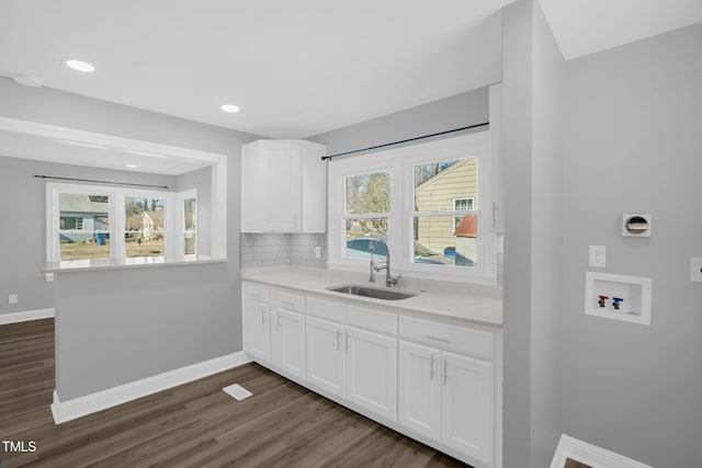 kitchen featuring tasteful backsplash, dark wood-type flooring, sink, and white cabinets