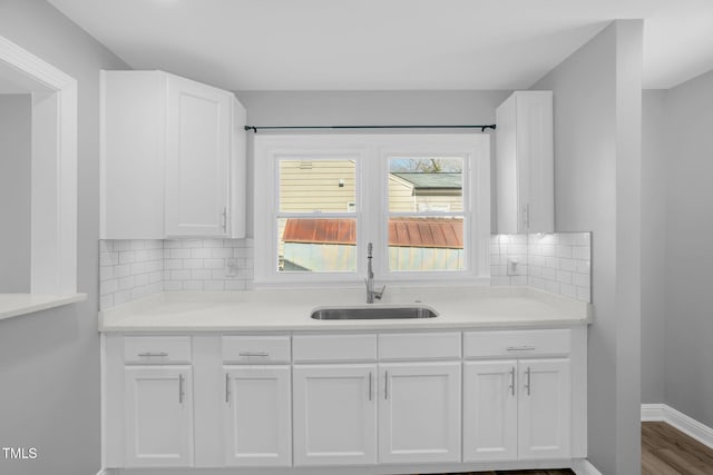 kitchen featuring white cabinetry, sink, decorative backsplash, and hardwood / wood-style floors