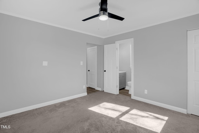 unfurnished bedroom featuring crown molding, carpet floors, ensuite bathroom, and ceiling fan