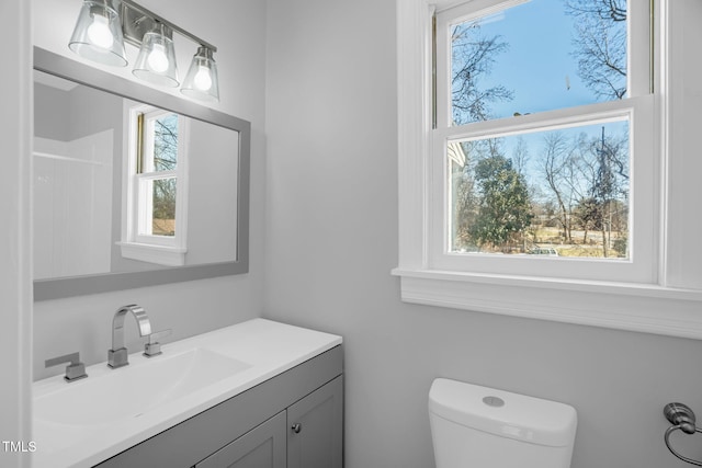 bathroom featuring vanity, a wealth of natural light, and toilet