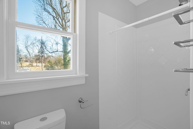 bathroom featuring walk in shower and toilet