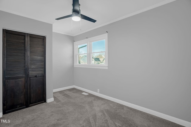 unfurnished bedroom with ornamental molding, light colored carpet, a closet, and ceiling fan