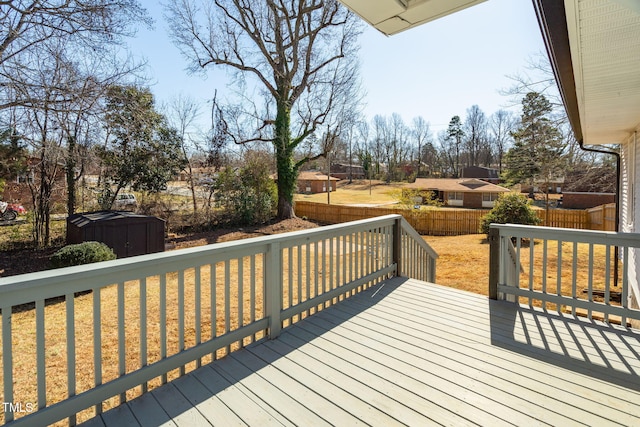 deck with a storage shed and a yard