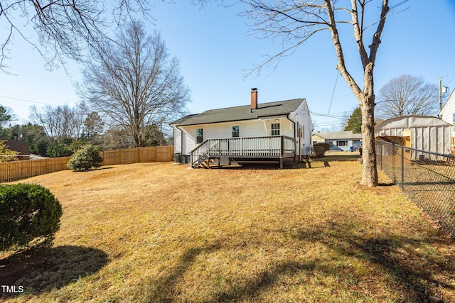 back of house with a wooden deck and a lawn