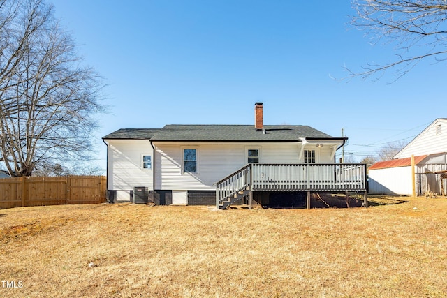 back of house featuring a lawn and a deck