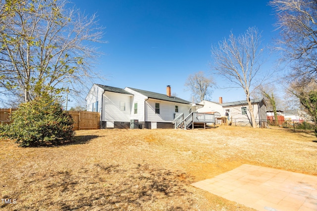 rear view of property with a yard, a deck, and a patio area