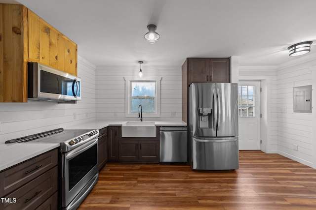 kitchen featuring sink, dark wood-type flooring, appliances with stainless steel finishes, dark brown cabinets, and electric panel