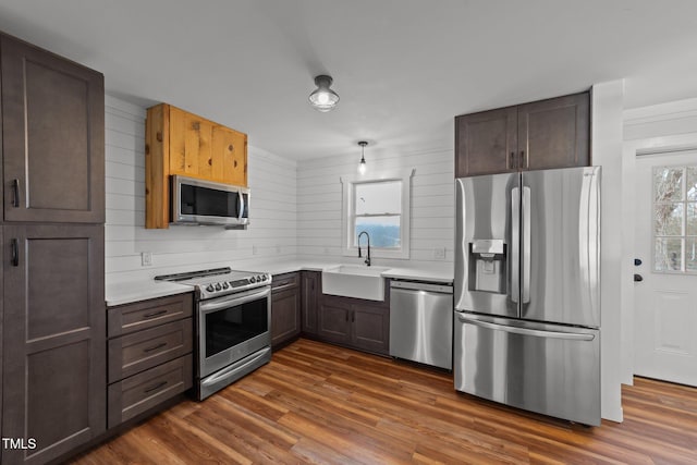 kitchen featuring stainless steel appliances, dark hardwood / wood-style flooring, sink, and dark brown cabinets