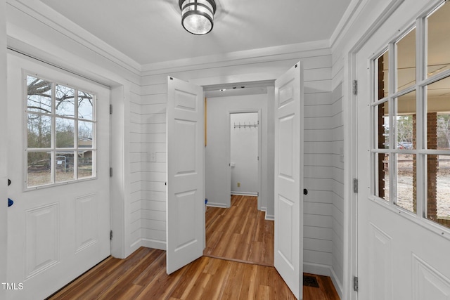 entrance foyer with hardwood / wood-style flooring and wooden walls