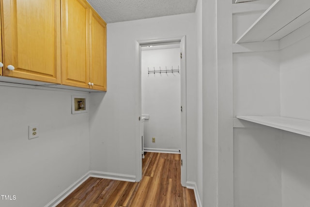 laundry area with cabinets, washer hookup, dark hardwood / wood-style floors, and a textured ceiling