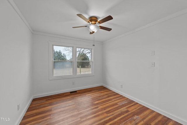 empty room featuring hardwood / wood-style floors, crown molding, and ceiling fan