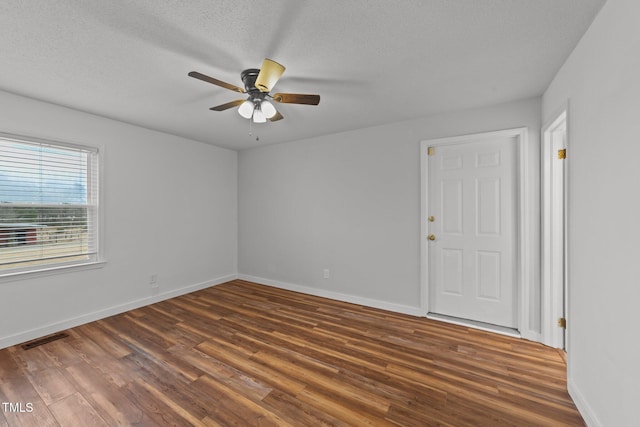 spare room with ceiling fan, dark hardwood / wood-style floors, and a textured ceiling