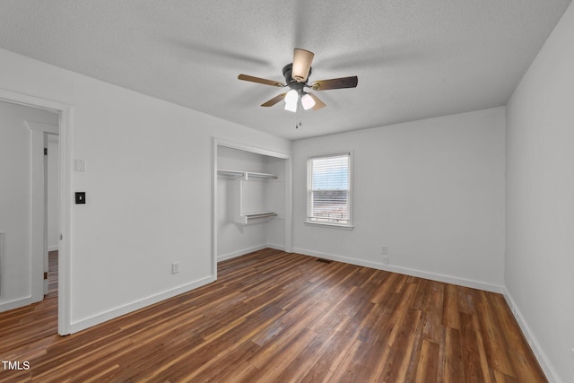 unfurnished bedroom with ceiling fan, a textured ceiling, dark hardwood / wood-style flooring, and a closet