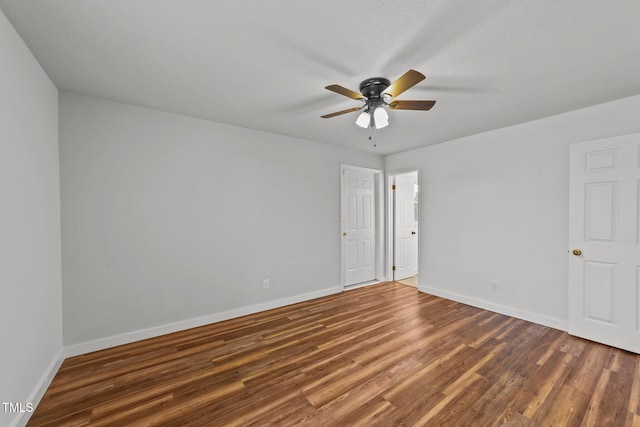 unfurnished room with ceiling fan, dark hardwood / wood-style flooring, and a textured ceiling