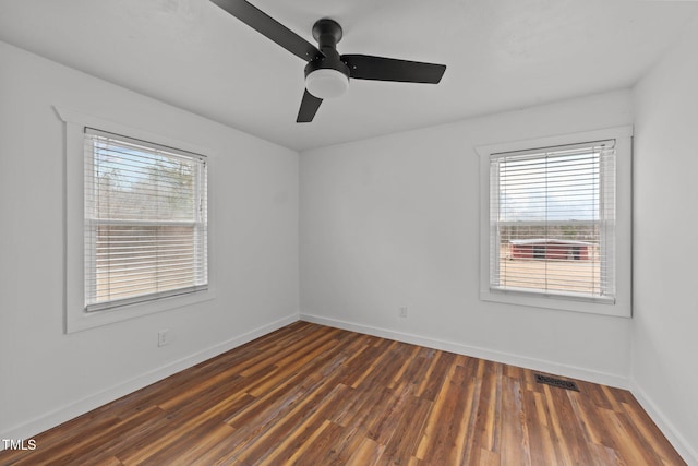 empty room with ceiling fan and dark hardwood / wood-style floors