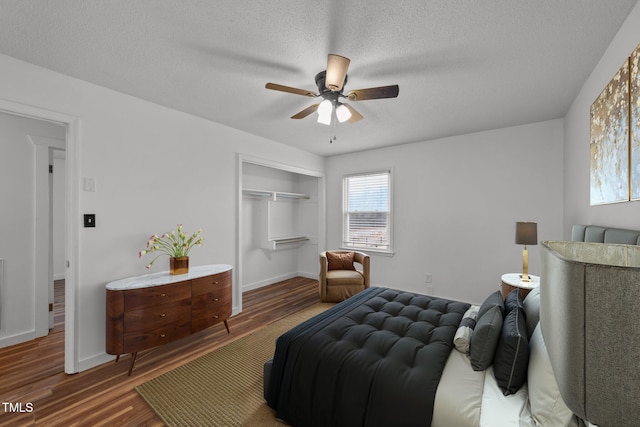 bedroom with ceiling fan, dark hardwood / wood-style floors, a closet, and a textured ceiling