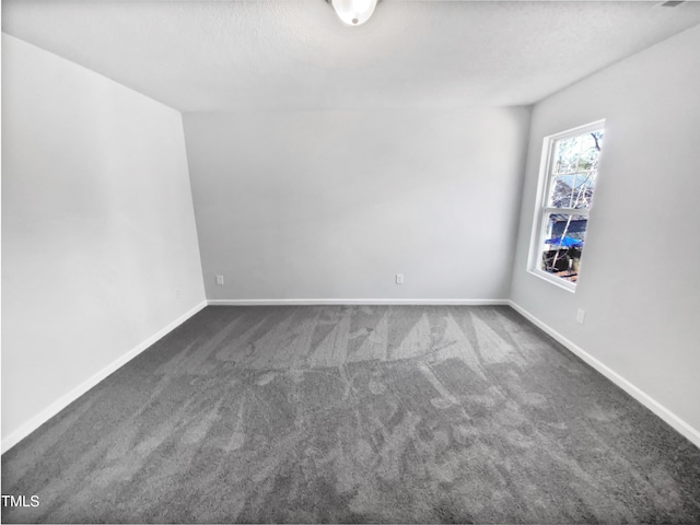 empty room with dark colored carpet