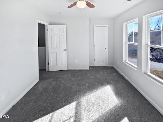 empty room featuring dark carpet and ceiling fan