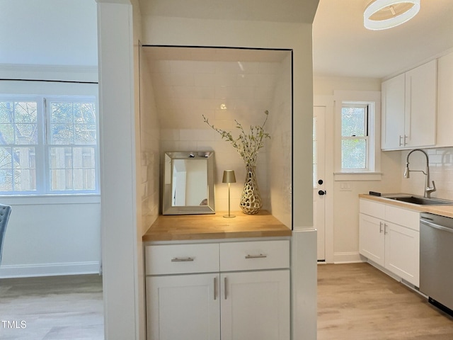 kitchen featuring sink, white cabinets, backsplash, stainless steel dishwasher, and light hardwood / wood-style flooring