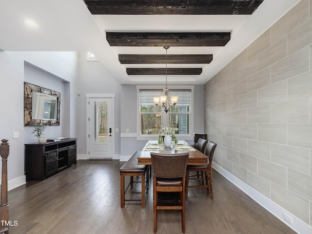 dining area featuring beam ceiling, dark wood finished floors, tile walls, baseboards, and a chandelier