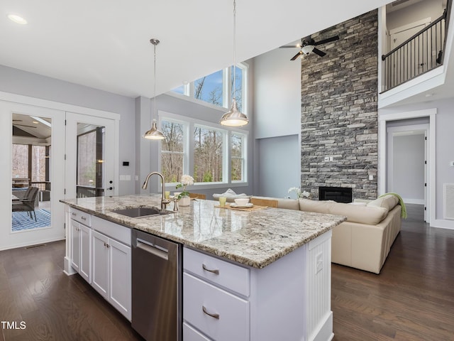 kitchen with light stone countertops, white cabinetry, dark wood-style flooring, a sink, and dishwasher