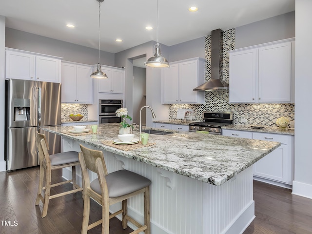 kitchen featuring a sink, wall chimney range hood, dark wood-style floors, and stainless steel appliances