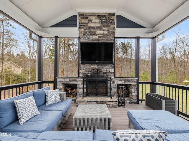 sunroom featuring lofted ceiling and an outdoor stone fireplace