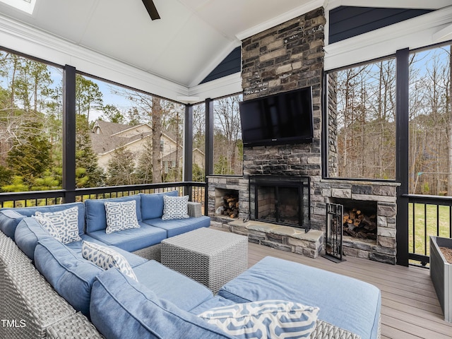 sunroom / solarium featuring lofted ceiling, an outdoor stone fireplace, and ceiling fan