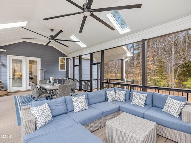 sunroom with vaulted ceiling with skylight and a ceiling fan