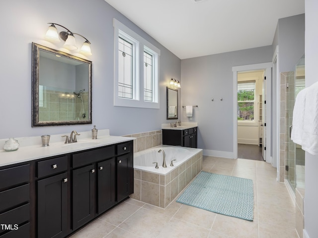 bathroom with tile patterned flooring, a shower stall, two vanities, and a sink