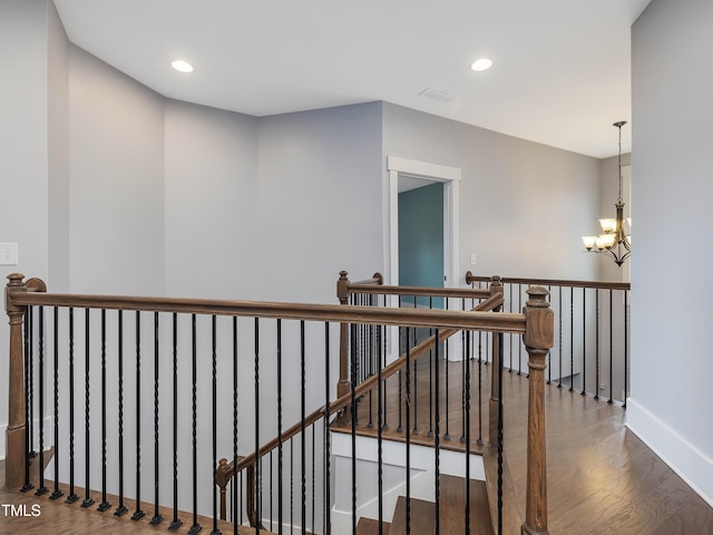 stairway featuring a notable chandelier, wood finished floors, recessed lighting, and baseboards