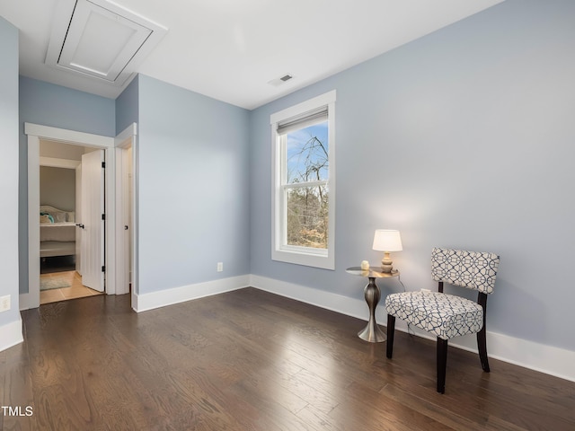 sitting room featuring visible vents, baseboards, and dark wood-type flooring