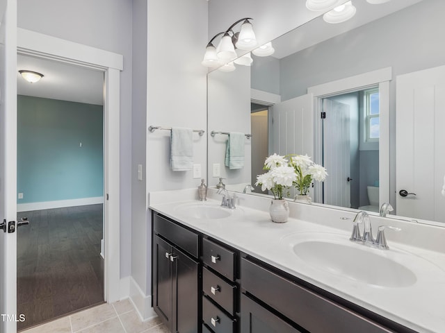 bathroom featuring double vanity, tile patterned flooring, toilet, and a sink